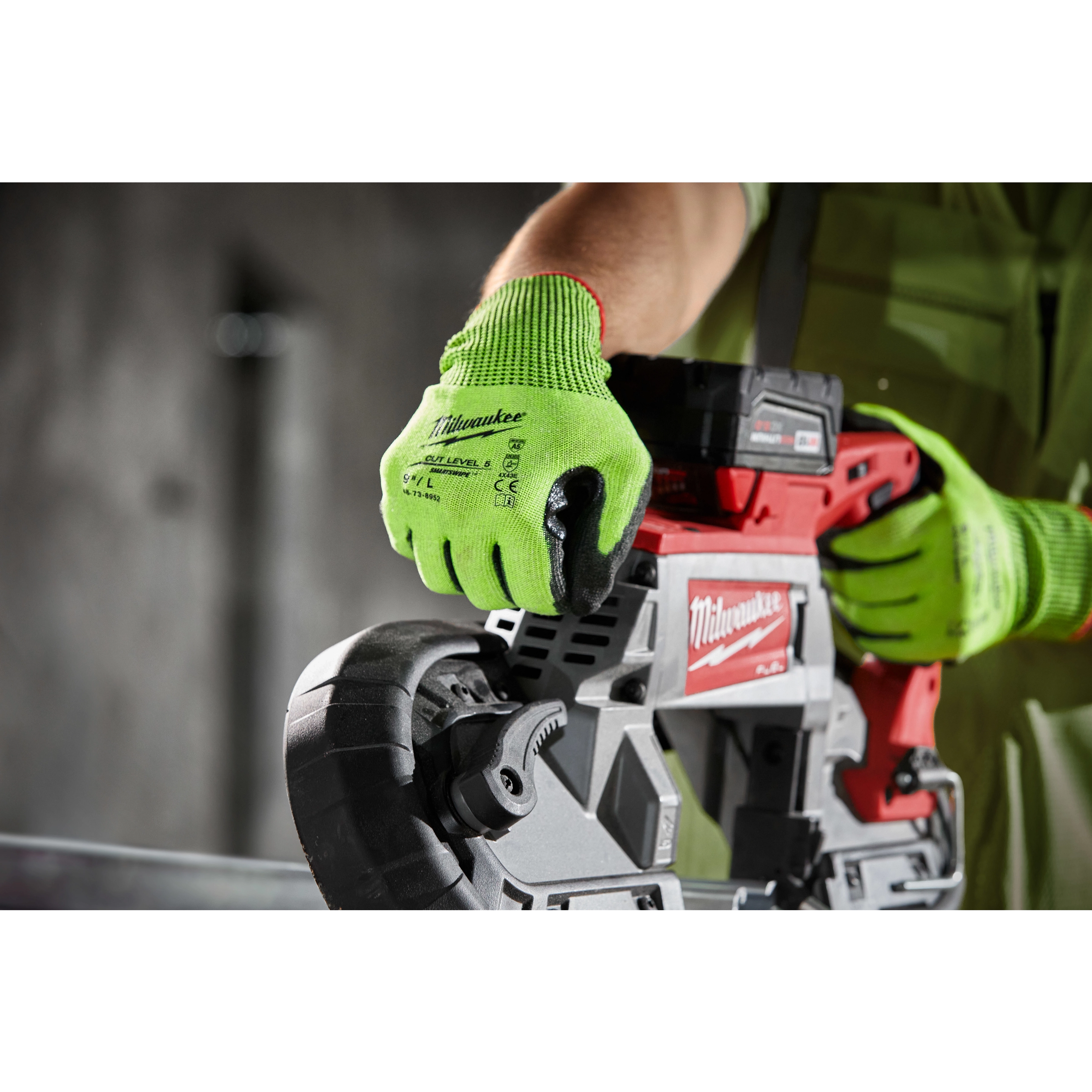 A person wearing High Visibility Cut Level 5 Polyurethane Dipped Glove - L operates a red and gray power tool in an industrial setting.