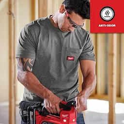 Man wearing a grey GRIDIRON Pocket T-Shirt - Short Sleeve Anti-odor while using a red power tool in a construction setting.