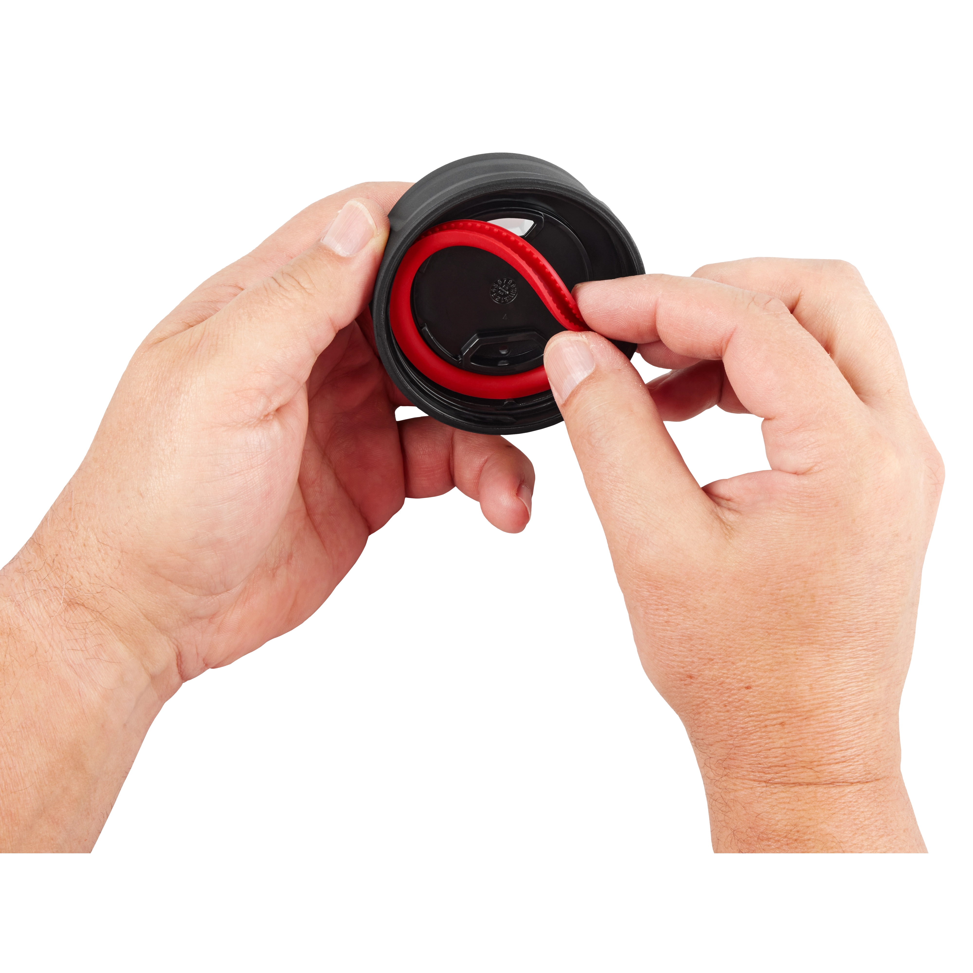 Hands holding the PACKOUT Sip Lid, featuring a black cap with a red, flexible spout being manipulated by the fingers.