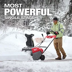 A person uses the M18 FUEL™ 21" Auger Propelled Dual Battery Single Stage Snow Blower to clear snow from a walkway. The image highlights the power of the snow blower in a snowy outdoor setting, with a prominent "MOST POWERFUL SINGLE STAGE" text written above.