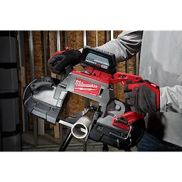 A person using a Milwaukee deep cut extreme thin band saw blade to cut a metal pipe, with the focus on the tool and blade.