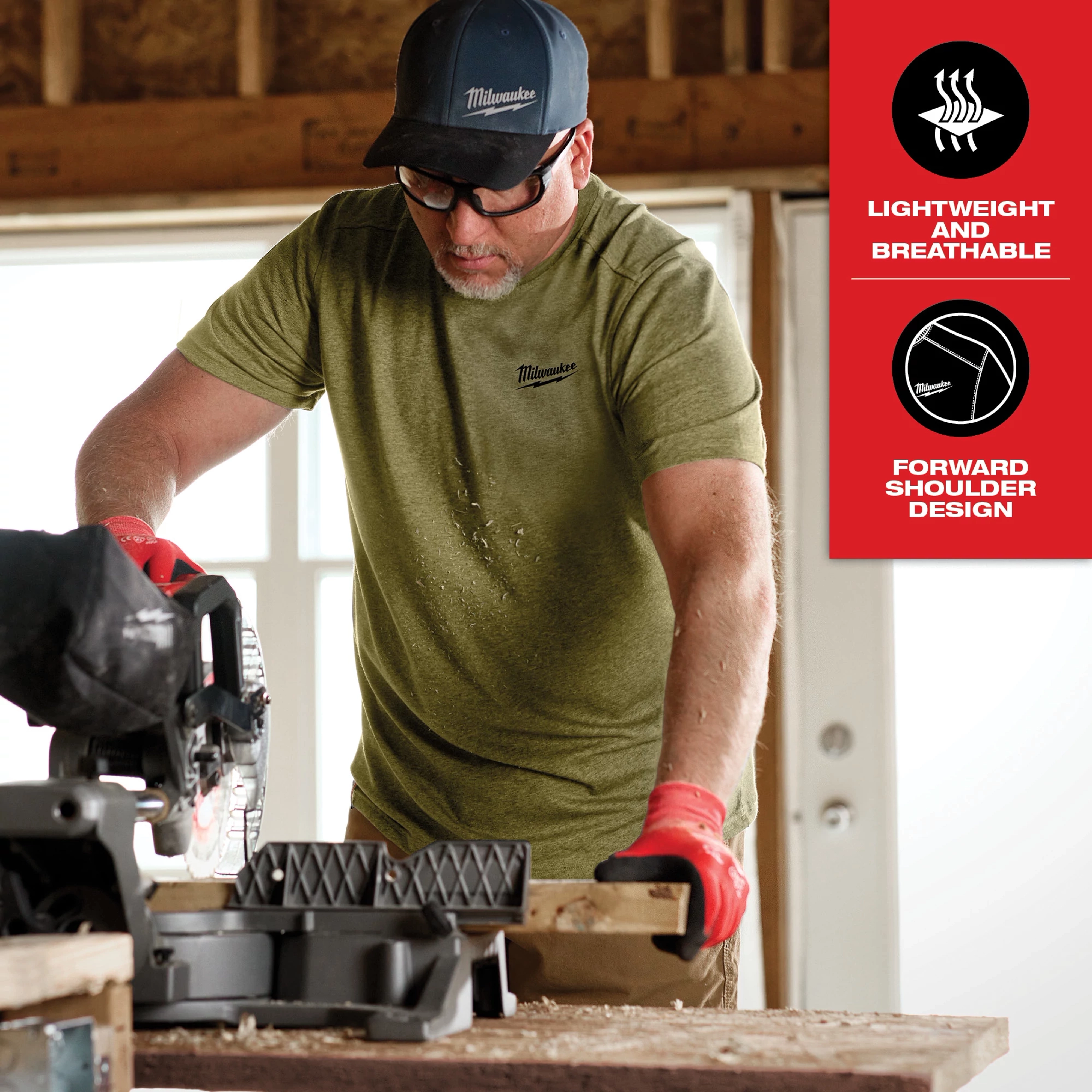 A person wearing the Hybrid Work Tee - Short Sleeve Feature Shot operates a saw on a wooden plank, highlighting its lightweight, breathable fabric and forward shoulder design.