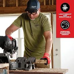 A person wearing the Hybrid Work Tee - Short Sleeve Feature Shot operates a saw on a wooden plank, highlighting its lightweight, breathable fabric and forward shoulder design.