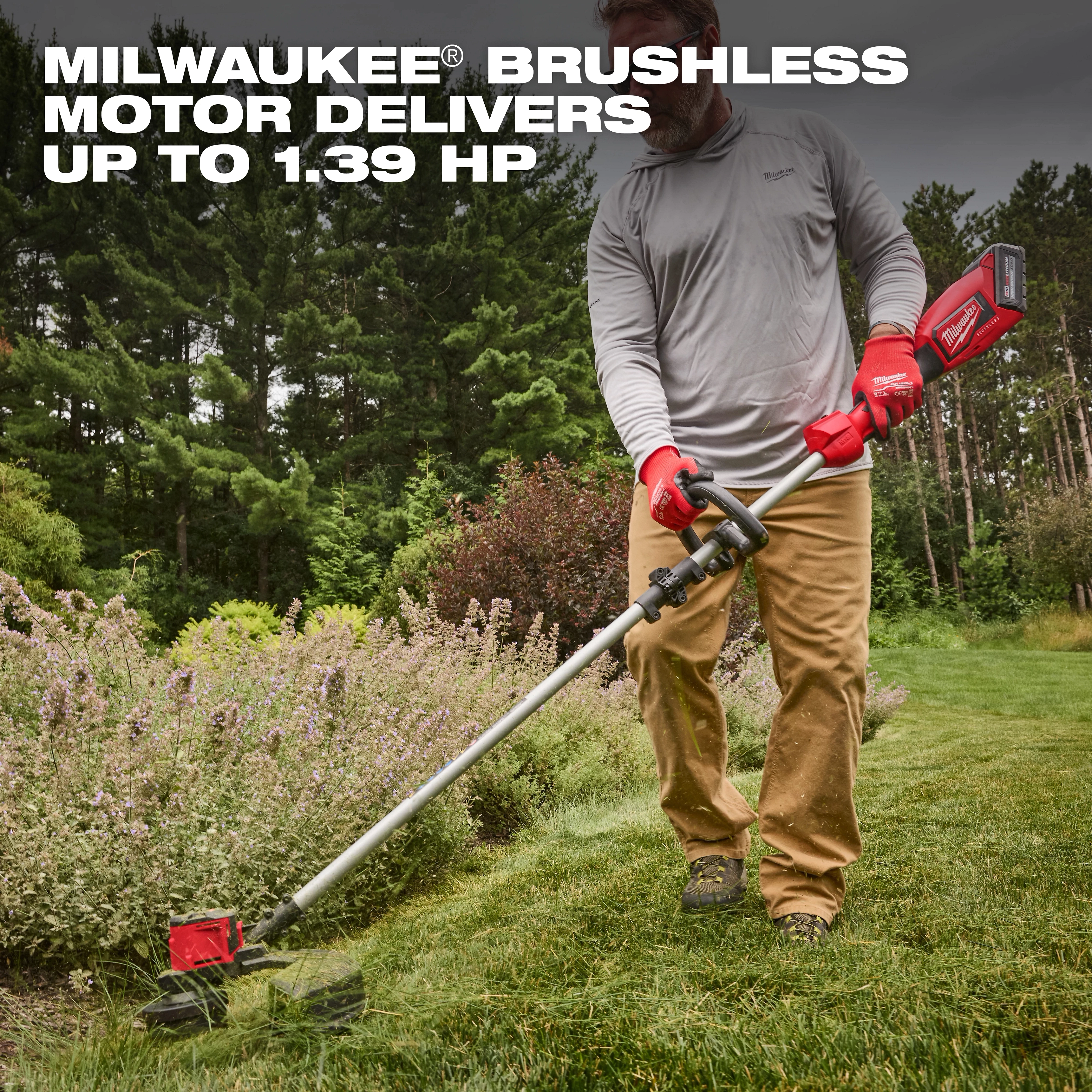 A person trims grass with the M18 Brushless String Trimmer, which has a powerful brushless motor delivering up to 1.39 horsepower. The trimmer features a red handle and is used in a well-maintained garden area surrounded by trees and shrubs.