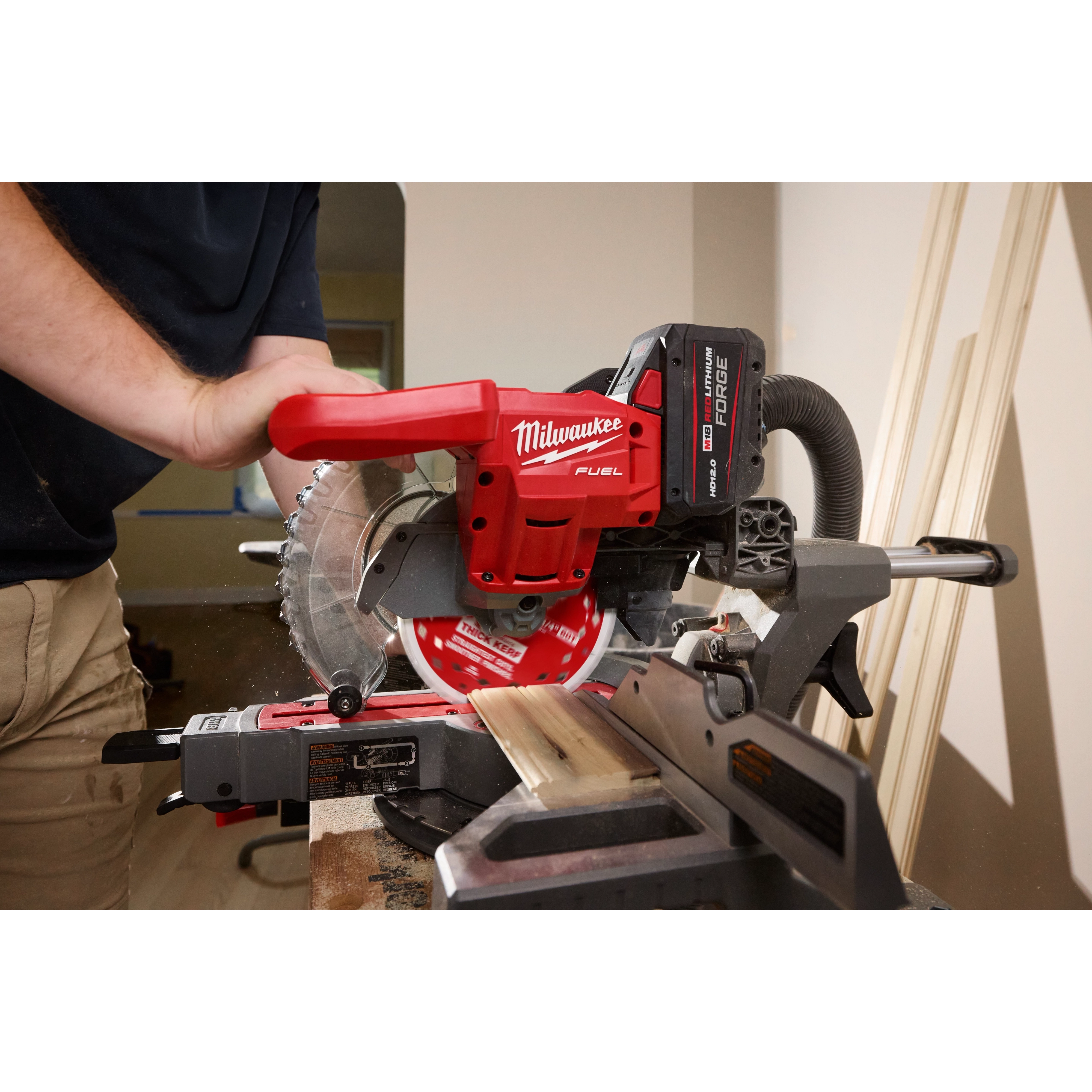 7-1/4" 60T Thick Kerf Ultra Finish Circular Saw Blade mounted on a red miter saw cutting a wood board indoors.