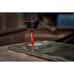 A drilling machine uses a 1/4" Diamond Grit Hole Saw to drill into a rectangular tile, generating a circular hole.