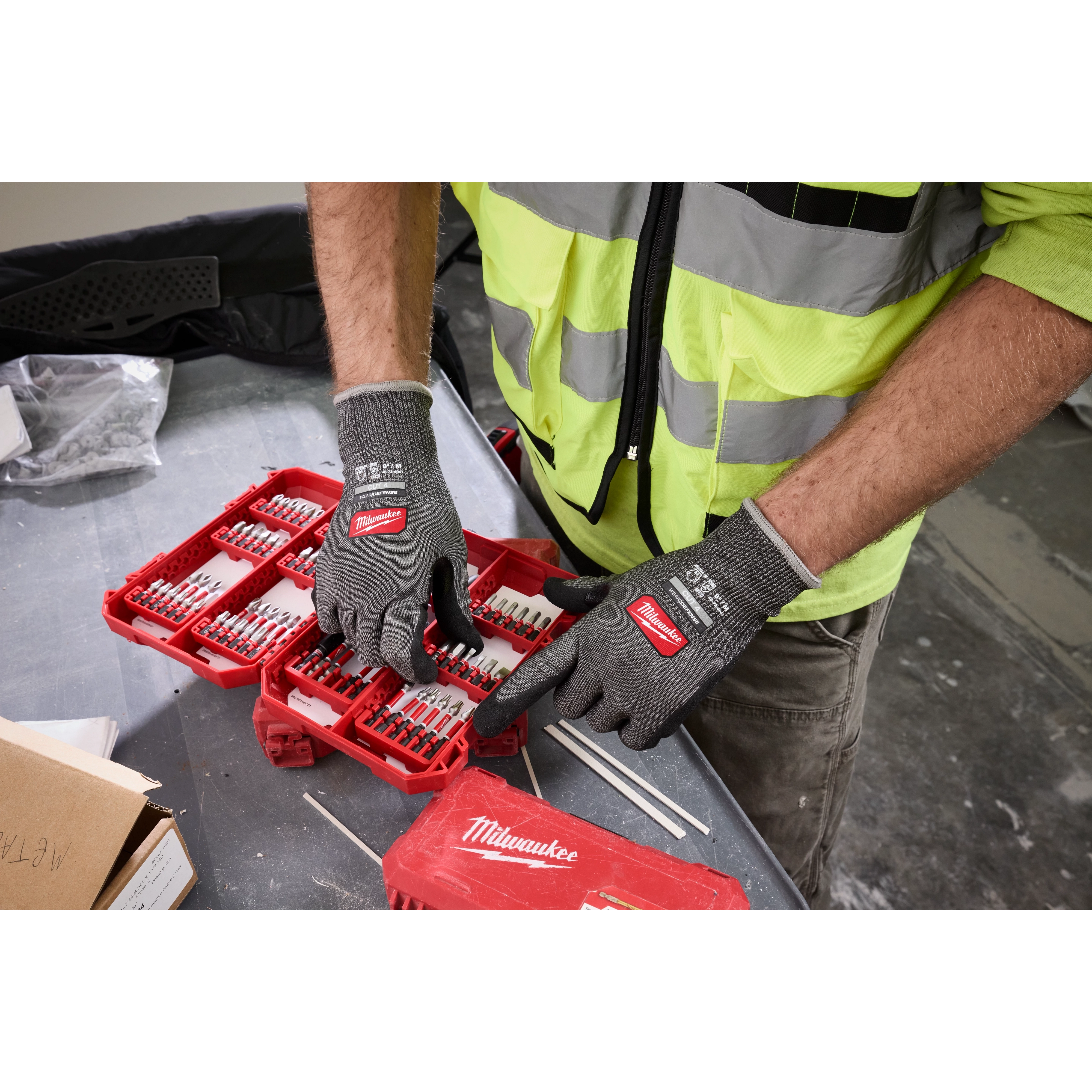Worker wearing Cut Level 4 High Dexterity Nitrile Dipped Gloves w/ WEAR-DEFENSE Protection organizing drill bits.