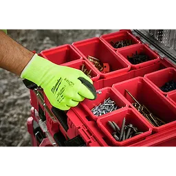 A person wearing a High Visibility Cut Level 1 Polyurethane Dipped Glove - M is handling a small screw. In the background, there is a red plastic organizer filled with various screws and fasteners.