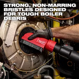 A person uses the AIR-TIP Boiler Coil Cleaning Brush Tool to clean a boiler, with strong bristles designed for tough debris.