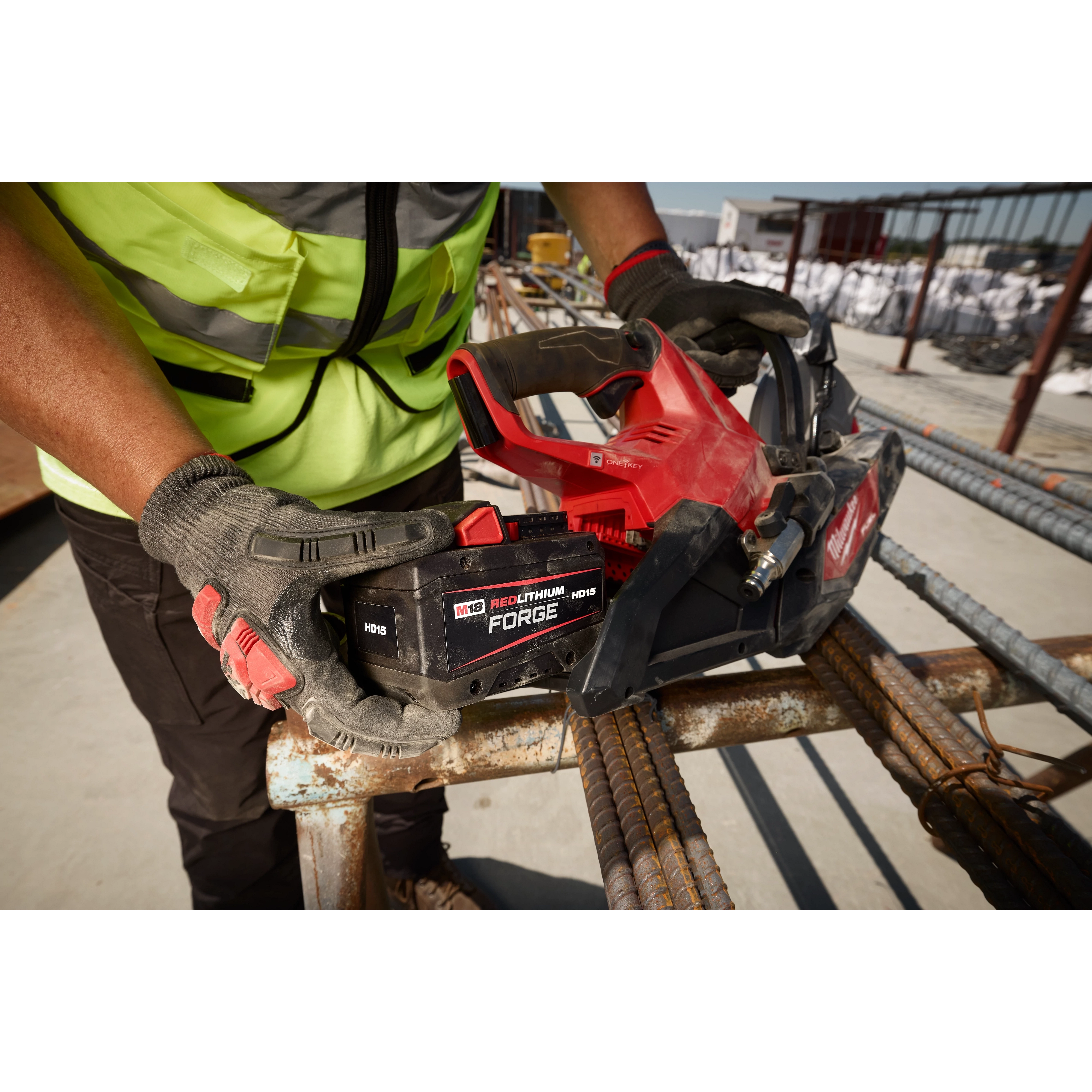 Worker holding M18 REDLITHIUM FORGE HD15 Battery Pack on M18 FUEL 9” Cut-Off Saw w/ ONE-KEY over rebar.