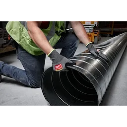 Person wearing Cut Level 9 High-Dexterity Nitrile Dipped Gloves - L, handling a large metal duct in a construction environment.