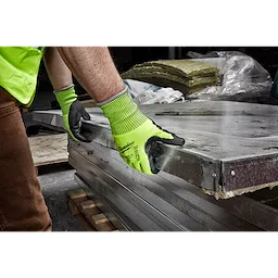 Person wearing Hi Vis Cut Gloves handling large metal sheets in a construction or warehouse setting.