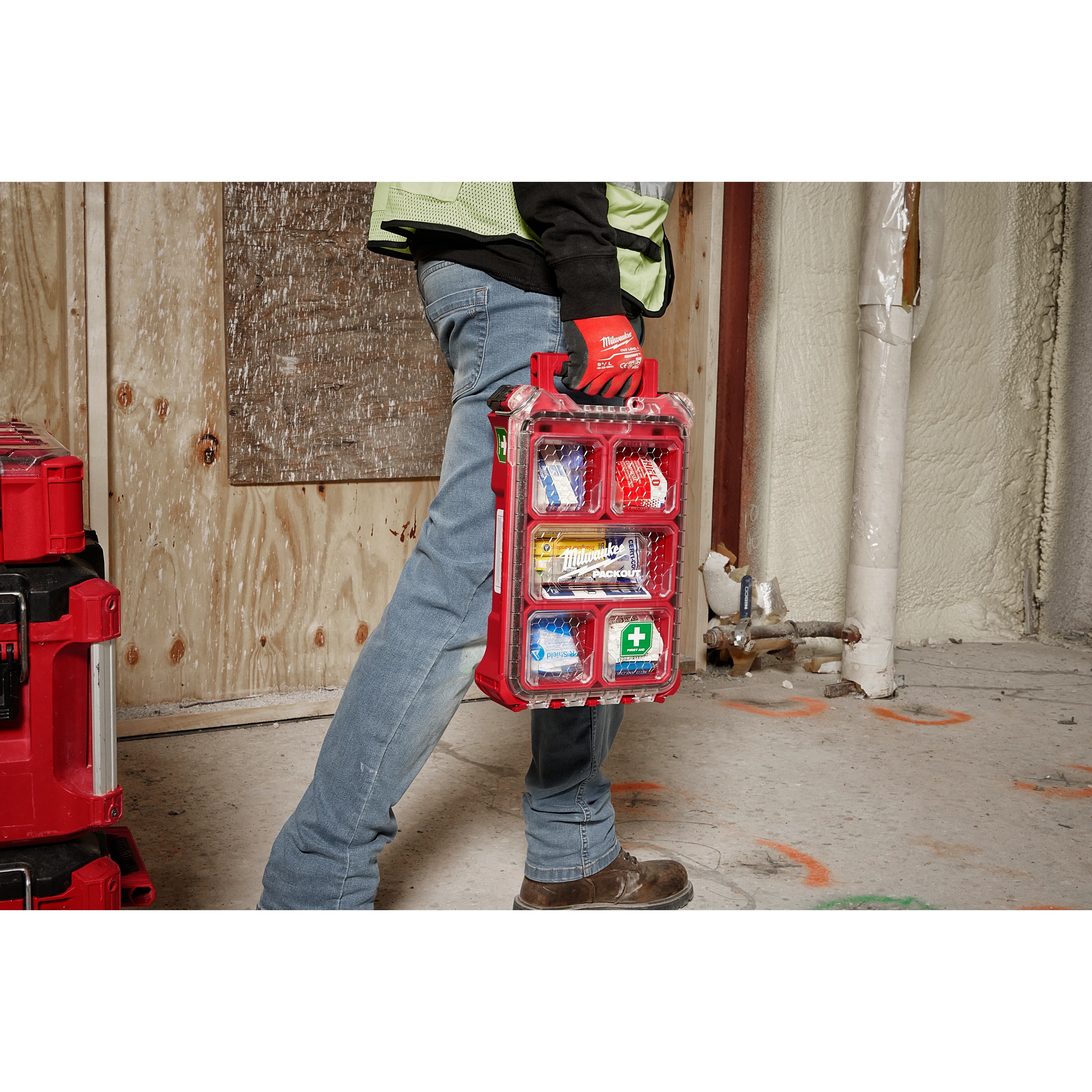 Worker carrying the 79PC Class A Type III PACKOUT™First Aid Kit  by its handle on the jobsite