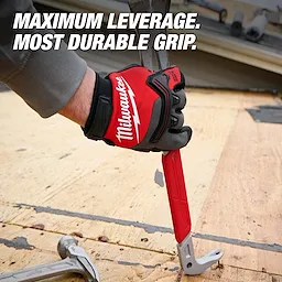 A gloved hand grips the 16" Molding Puller, a red tool designed for maximum leverage and durability in construction tasks. The text reads, "Maximum Leverage. Most Durable Grip." The background features a wooden panel, suggesting active use on a building site.
