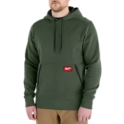Man wearing a green FREEFLEX Pullover Hoodie with a front pocket and black drawstrings.
