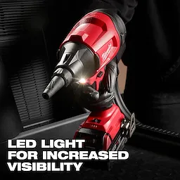 The M18™ Brushless Precision Blower is shown being used, featuring a built-in LED light. The red and black blower has a compact design and is held by a gloved hand. Text overlay states "LED LIGHT FOR INCREASED VISIBILITY."