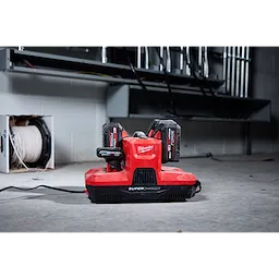 M18 & M12 Four Bay Simultaneous Super Charger with PACKOUT Compatibility charging two batteries in a workshop setting.