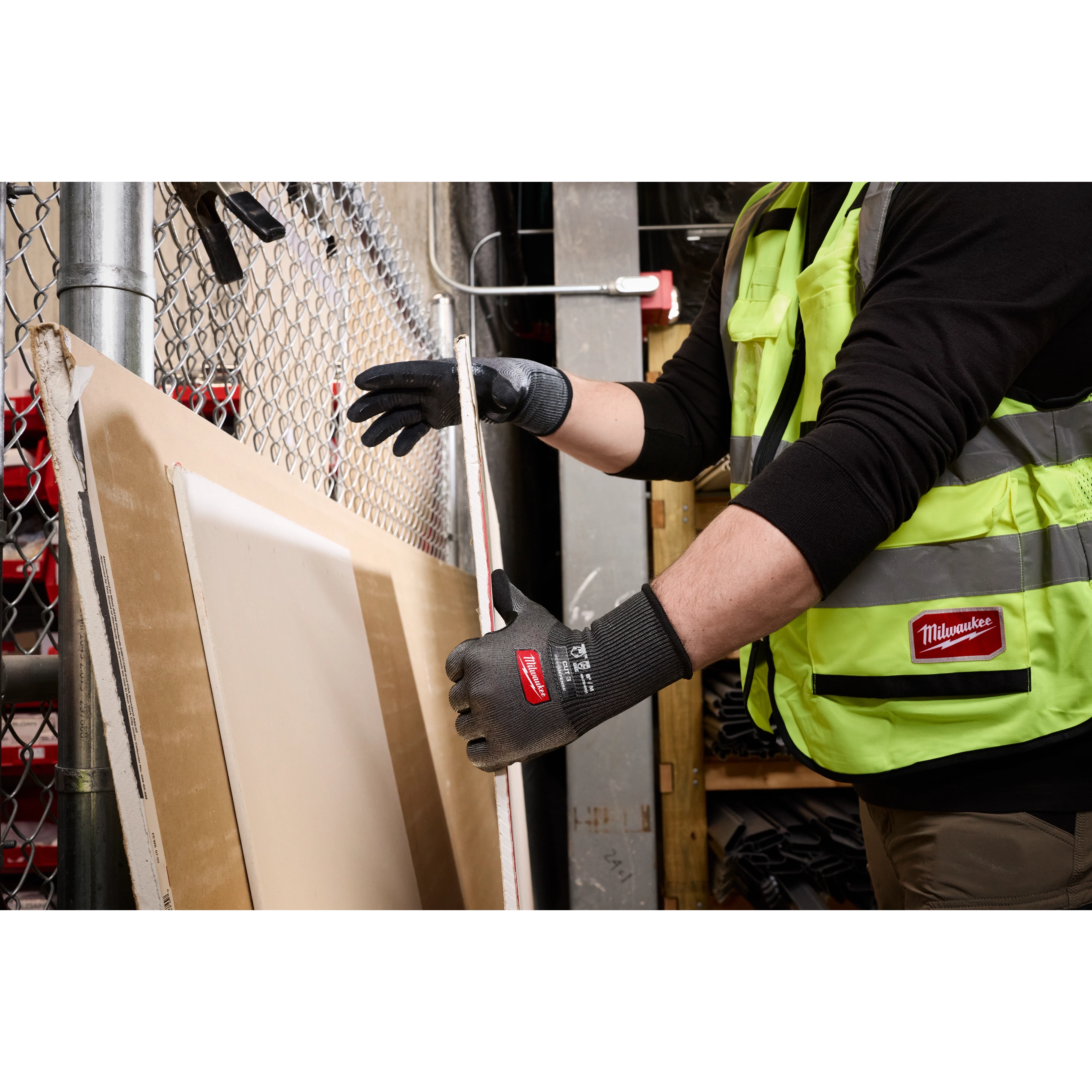 Worker wearing Cut Level 3 High Dexterity Nitrile Dipped Gloves w/ WEAR-DEFENSE Protection handling boards.