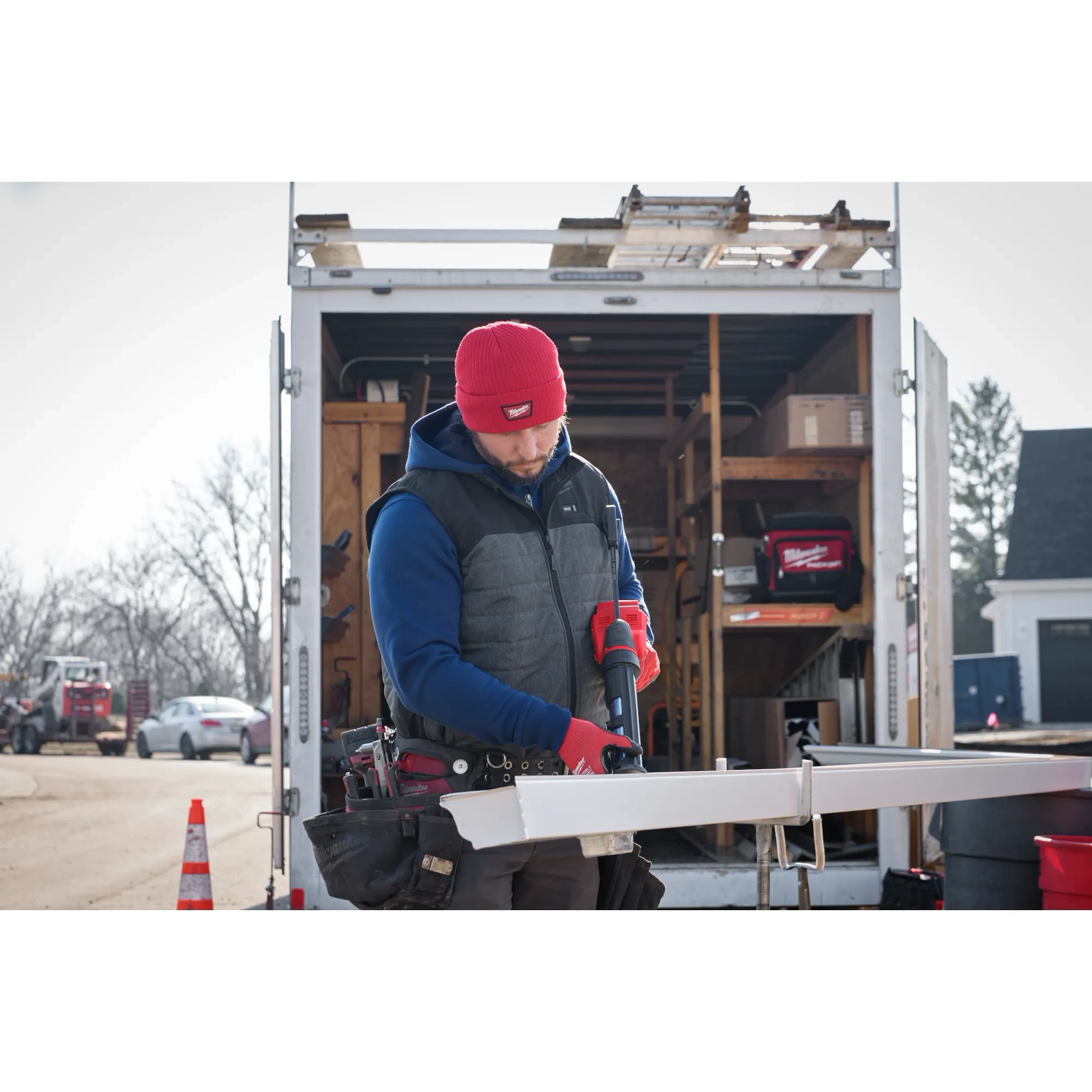 Image of a man on a jobsite wearing the Milwaukee Rib-Knit Cuffed Beanie in red