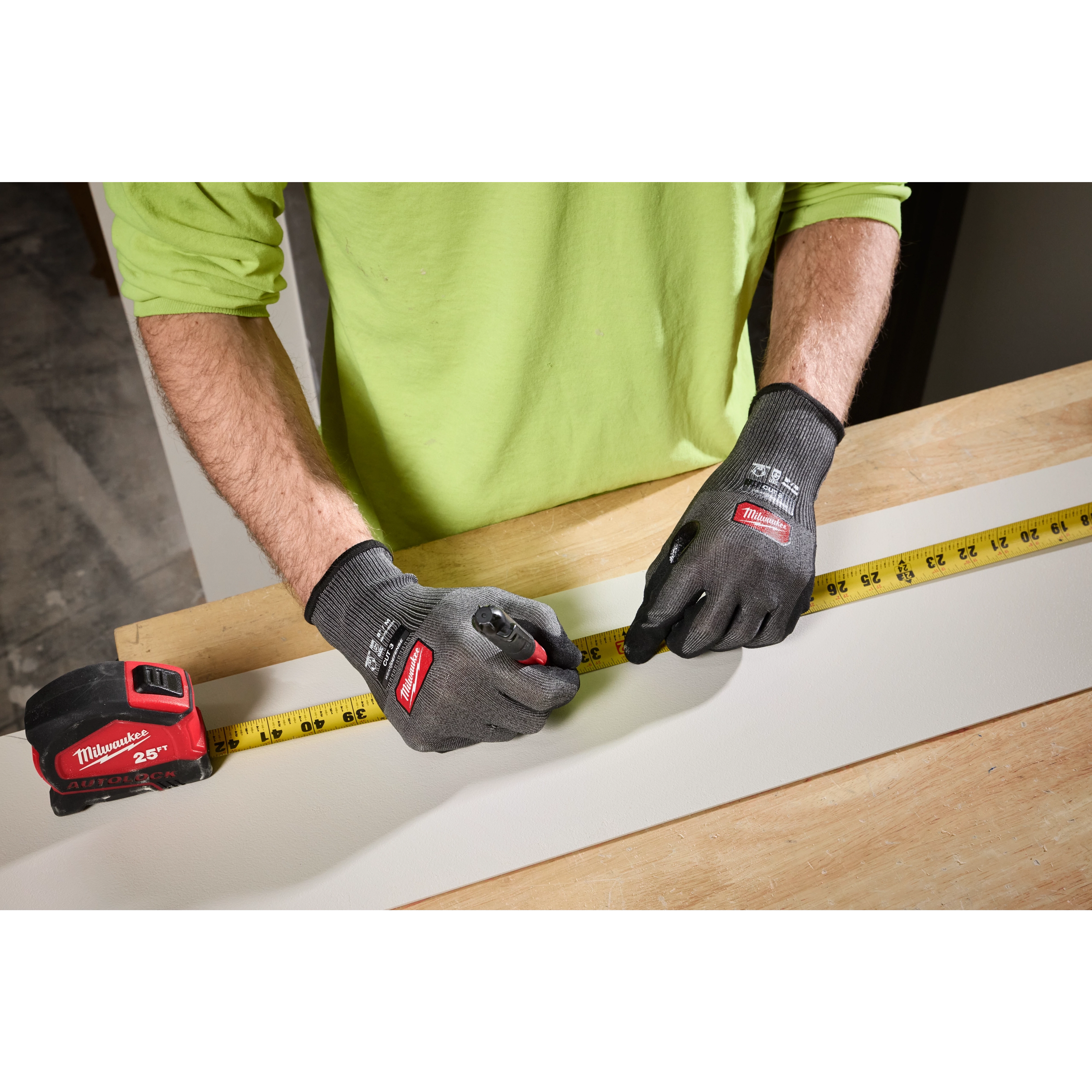 Person measuring wood while wearing Cut Level 3 High Dexterity Nitrile Dipped Gloves w/ WEAR-DEFENSE Protection.