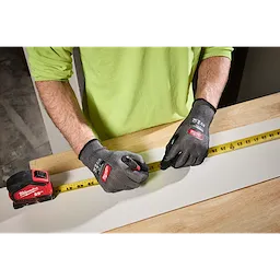 Person measuring wood while wearing Cut Level 3 High Dexterity Nitrile Dipped Gloves w/ WEAR-DEFENSE Protection.