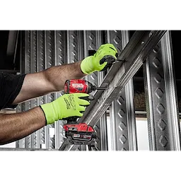 Person using a red power drill while wearing bright green Hi Vis Cut Gloves, working on metal framing in a construction setting.