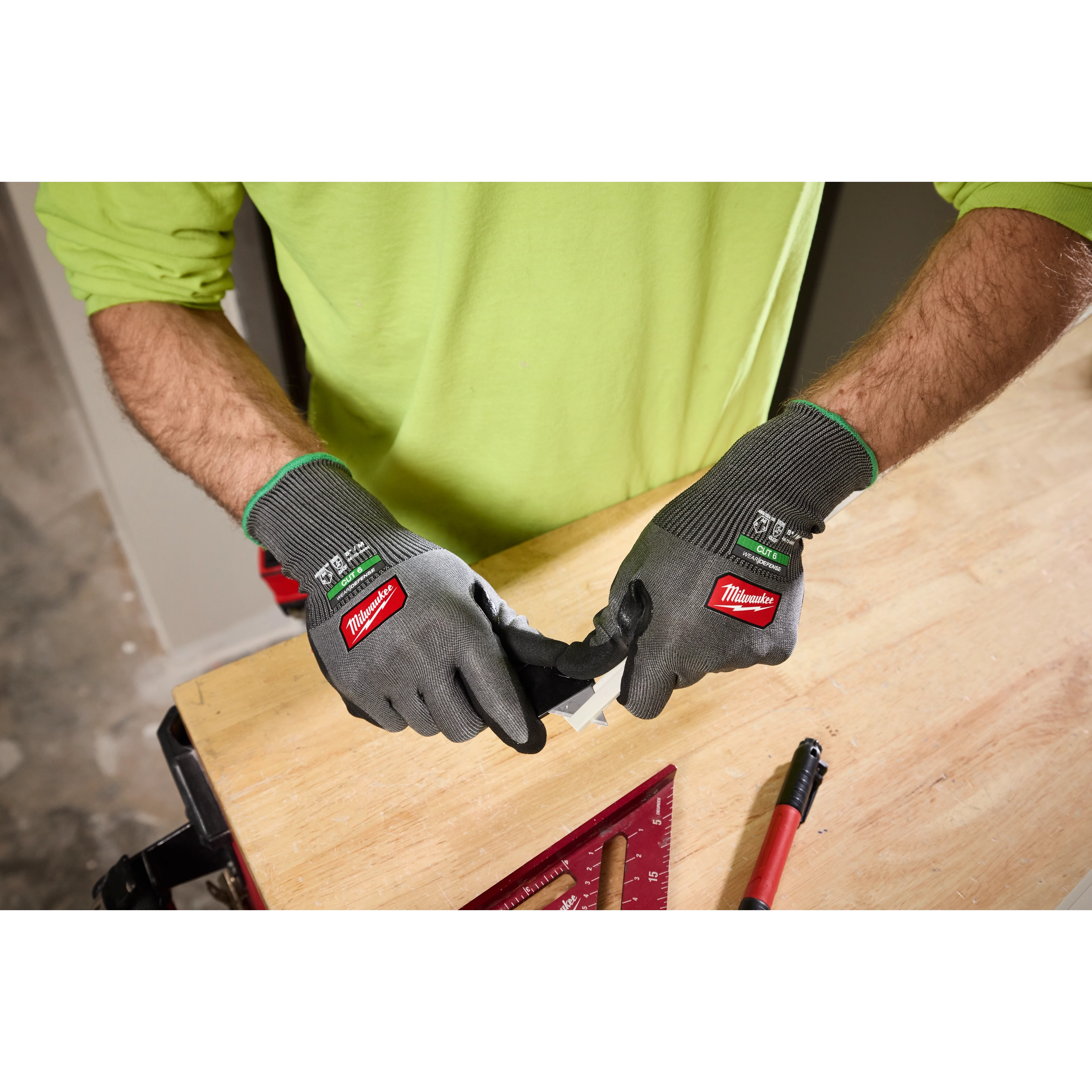 Hands wearing Cut Level 6 High Dexterity Nitrile Dipped Gloves w/ WEAR-DEFENSE Protection working on a wooden surface.