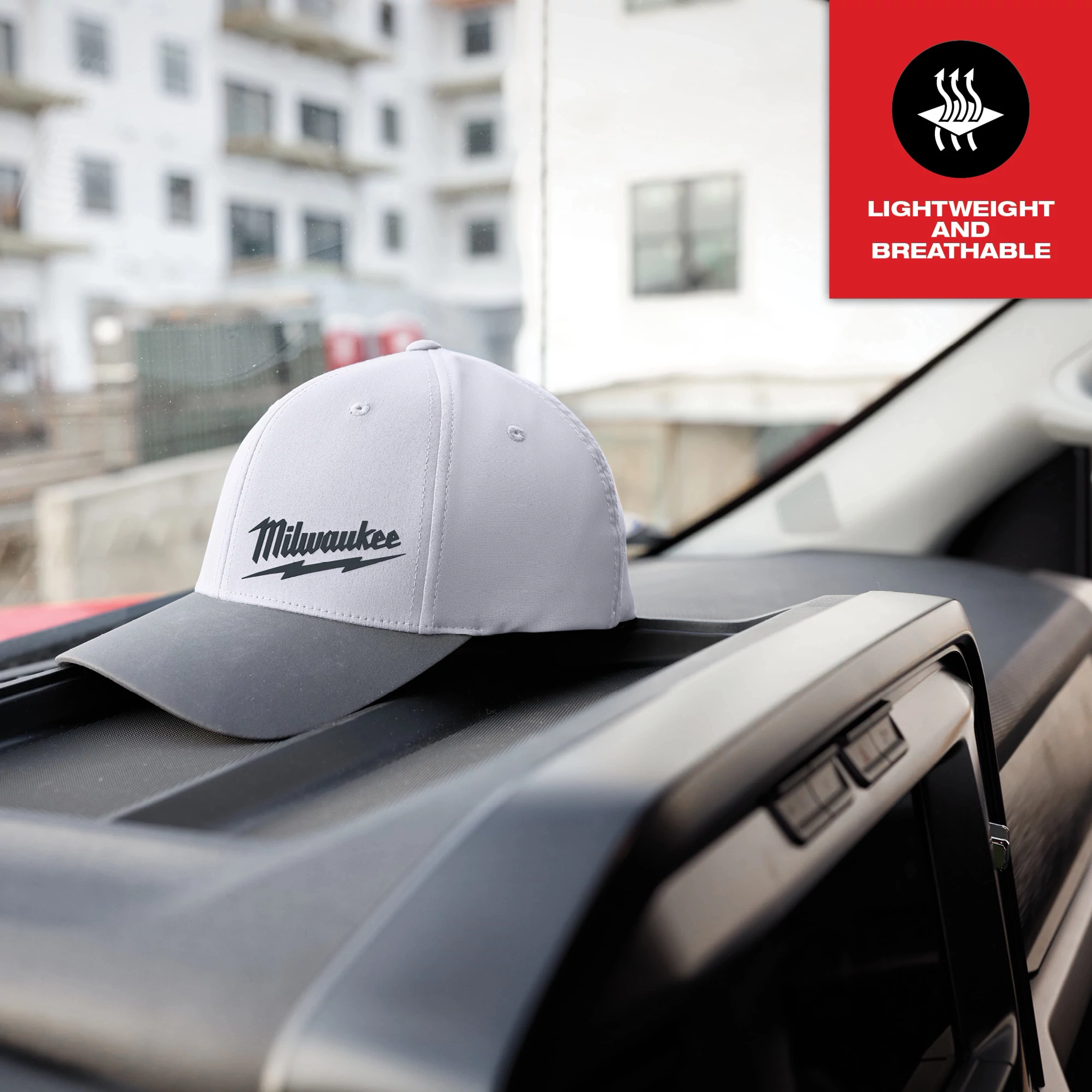 WORKSKIN Performance Fitted Hat - Gray, featuring the product logo, rests on a car dashboard with a "Lightweight and Breathable" icon.