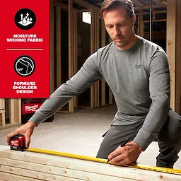Man wearing FREEFLEX Hybrid Work Tee - Long Sleeve in a construction setting, demonstrating its moisture-wicking fabric and forward shoulder design.