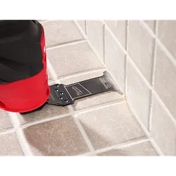 Image of the OPEN-LOK™ DIAMOND MAX™ Diamond Grit Grout Removal Multi-Tool Plunge Blade being used in a Milwaukee Multi-Tool on tile