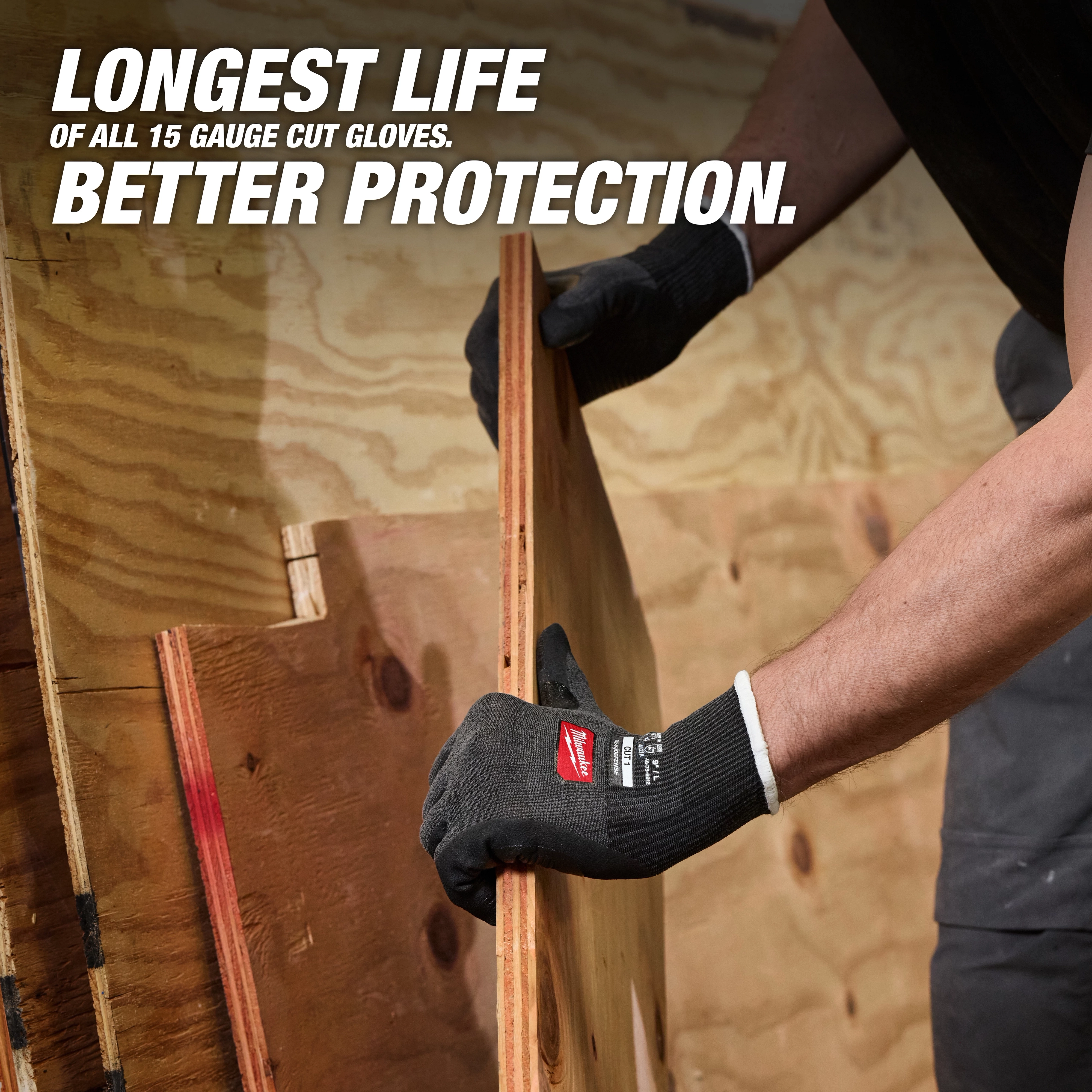Hands wearing Cut Level 1 Nitrile Dipped Gloves w/ WEAR-DEFENSE Protection lifting a plywood board.