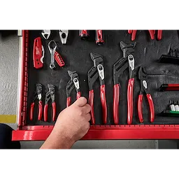 A hand reaches into a red toolbox drawer that contains various sizes of Pliers and Wrenches, all part of a family featuring black metal heads and red handles.