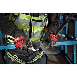 Worker wearing Impact Cut Level 5 Goatskin Leather Gloves handles a metal object while dressed in safety gear at a construction site.
