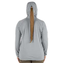 Back view of a person wearing the Women's WORKSKIN Hooded Sun Shirt – Gray. The shirt features a hood with an opening for a ponytail, long sleeves, and a relaxed fit. The color is a light gray, and the material appears to be lightweight and breathable.