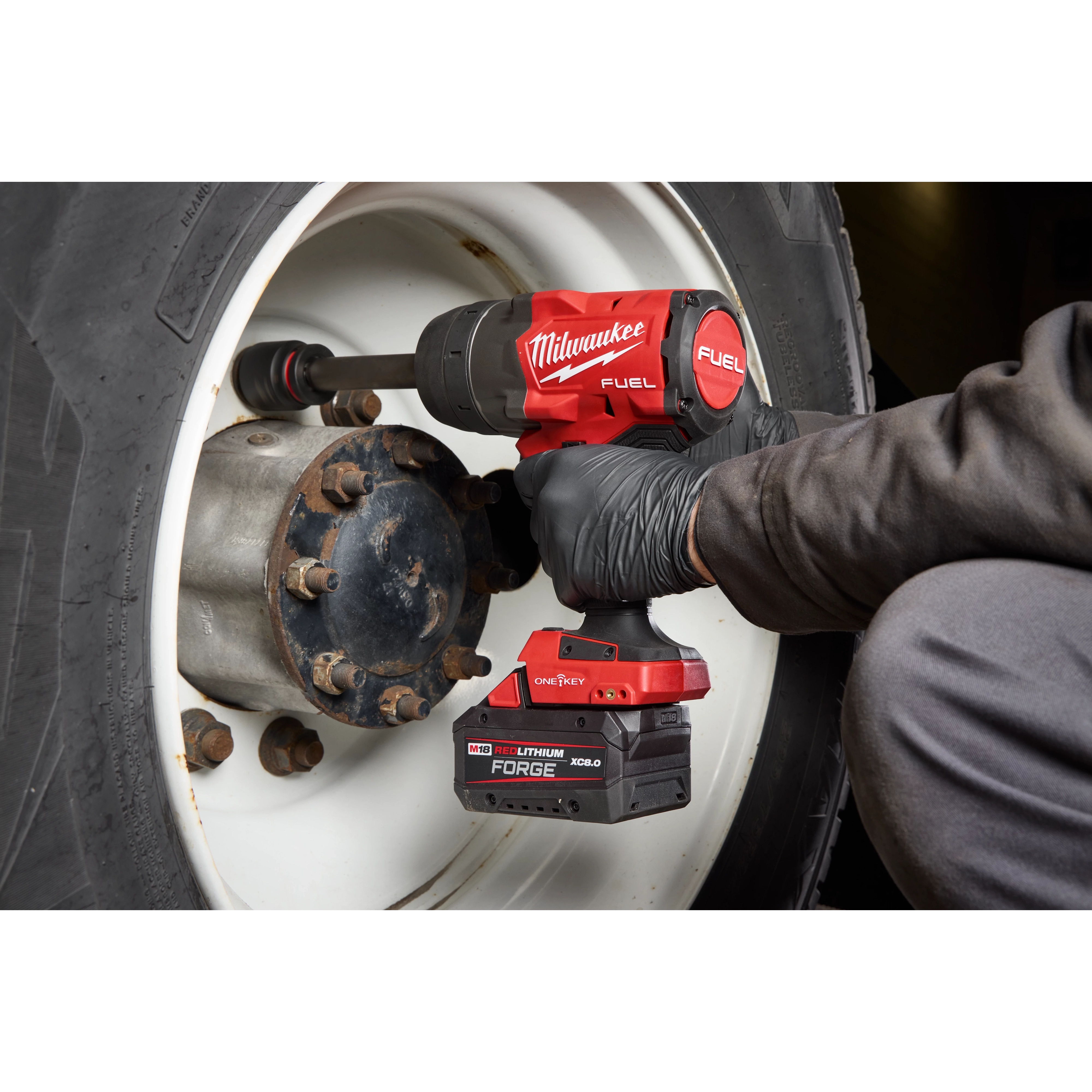 M18 FUEL 3/4" Extended Anvil High Torque Impact Wrench w/ ONE-KEY loosening lug nuts on a large vehicle wheel.
