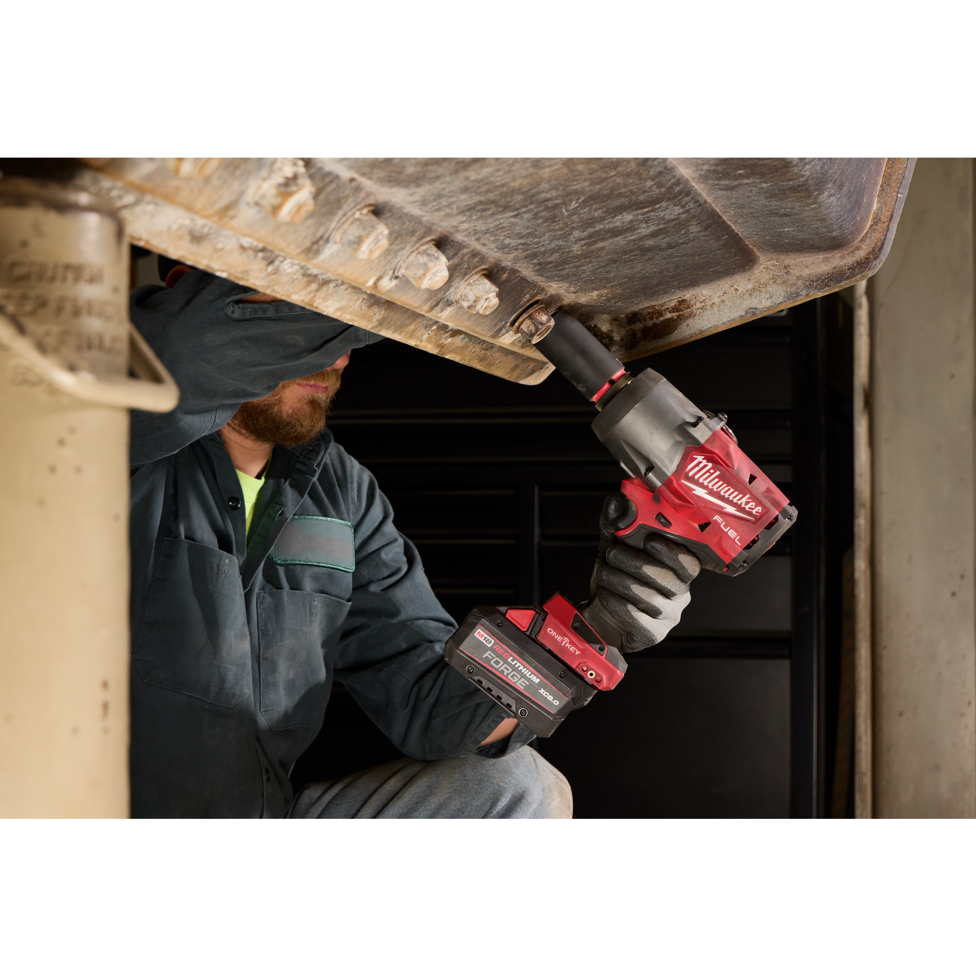 Worker using M18 FUEL 3/4" High Torque Impact Wrench w/ ONE-KEY on a large metal structure.