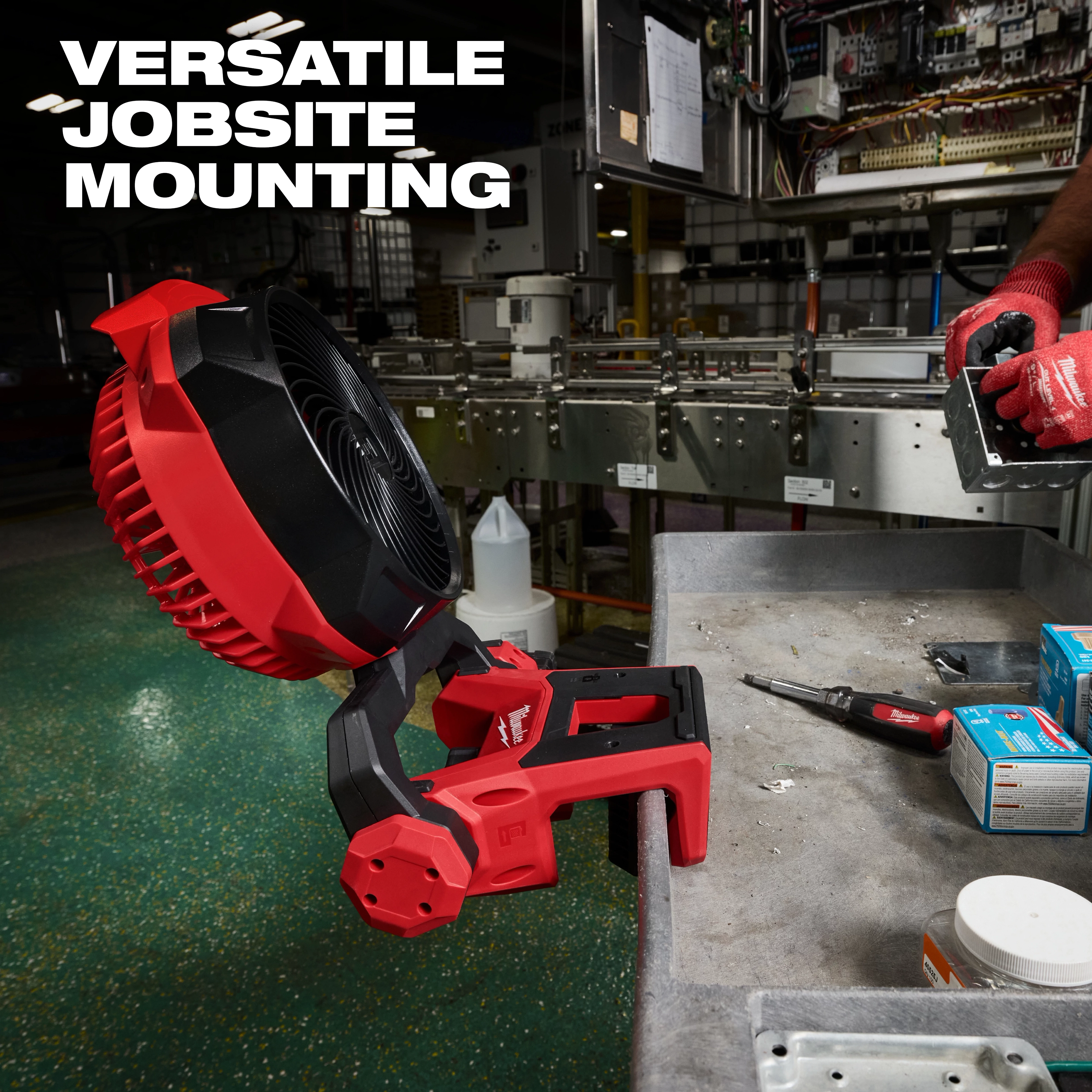 M18 Brushless Scissor Lift Fan mounted on the edge of a workbench in an industrial setting.