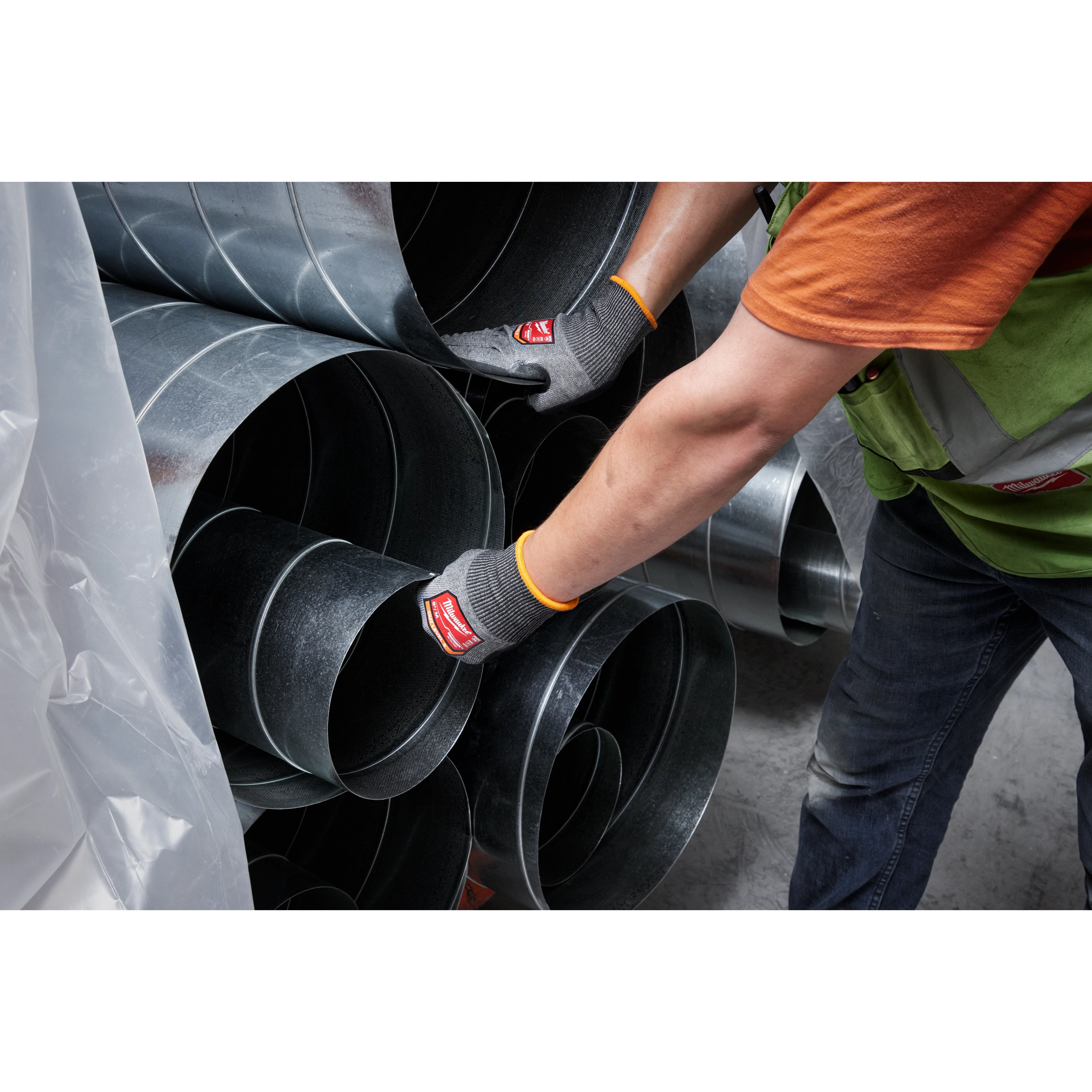 Person wearing Cut Level 8 High-Dexterity Nitrile Dipped Gloves - L handles large metal ducts, showcasing the glove's protective features.
