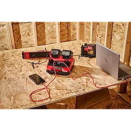 M18 TOP-OFF 350W Power Supply & Charger with devices connected on a plywood worktable in a framed room.