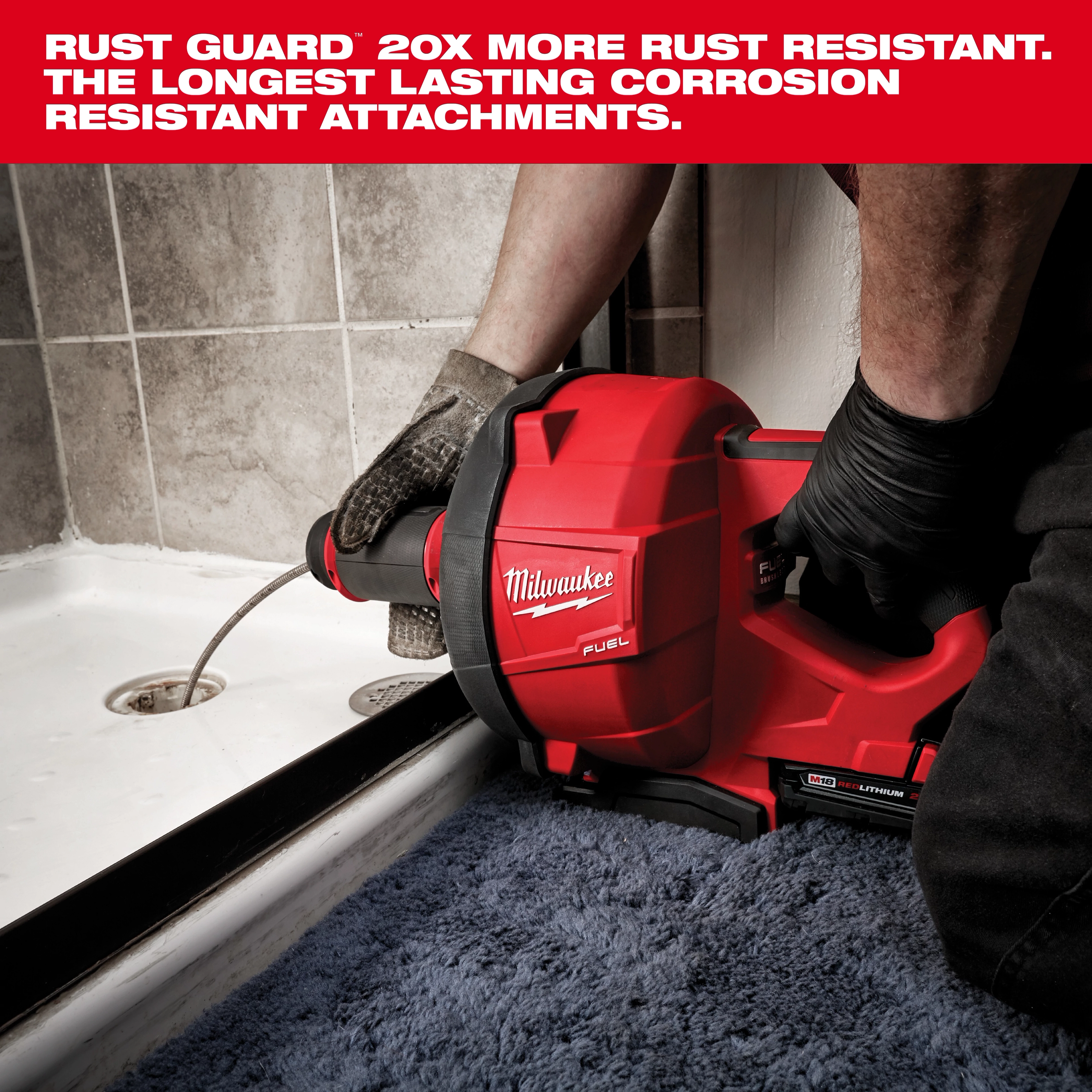 A person uses the Milwaukee Fuel plumbing tool to clean a drain in a shower. The tool is red with black accents and is held by a gloved user. Text above highlights the product's superior rust resistance and longevity.