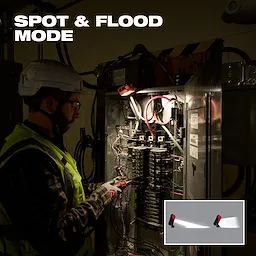 Worker using Milwaukee Rechargeable Pivoting Task Light w/ Spot Mode to illuminate an open electrical panel.