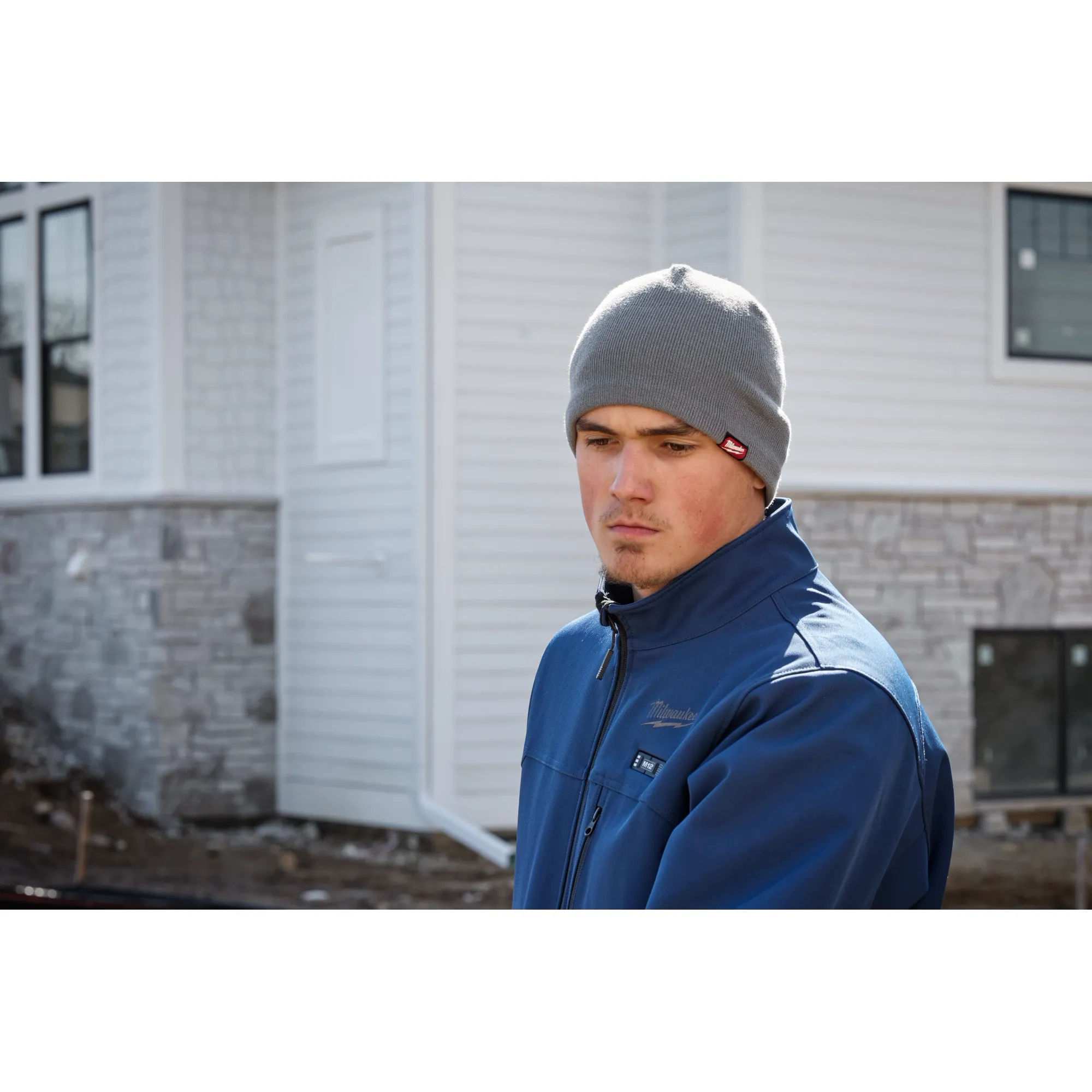 Image of a man on a jobsite wearing the Milwaukee Fleece-Lined Beanie in gray