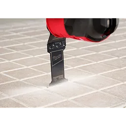 Image of the OPEN-LOK™ DIAMOND MAX™ Diamond Grit Grout Removal Multi-Tool Plunge Blade being used in a Milwaukee Multi-Tool on tile