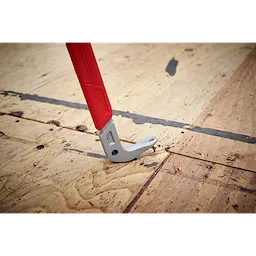The 16" Molding Puller has a metal prying end with a red handle designed for removing moldings and trim from wooden surfaces. The tool is shown in use on a wooden floor.