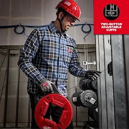 Man in a GRIDIRON Flannel Shirt working at a construction site. Features two-button adjustable cuffs in an industrial setting.