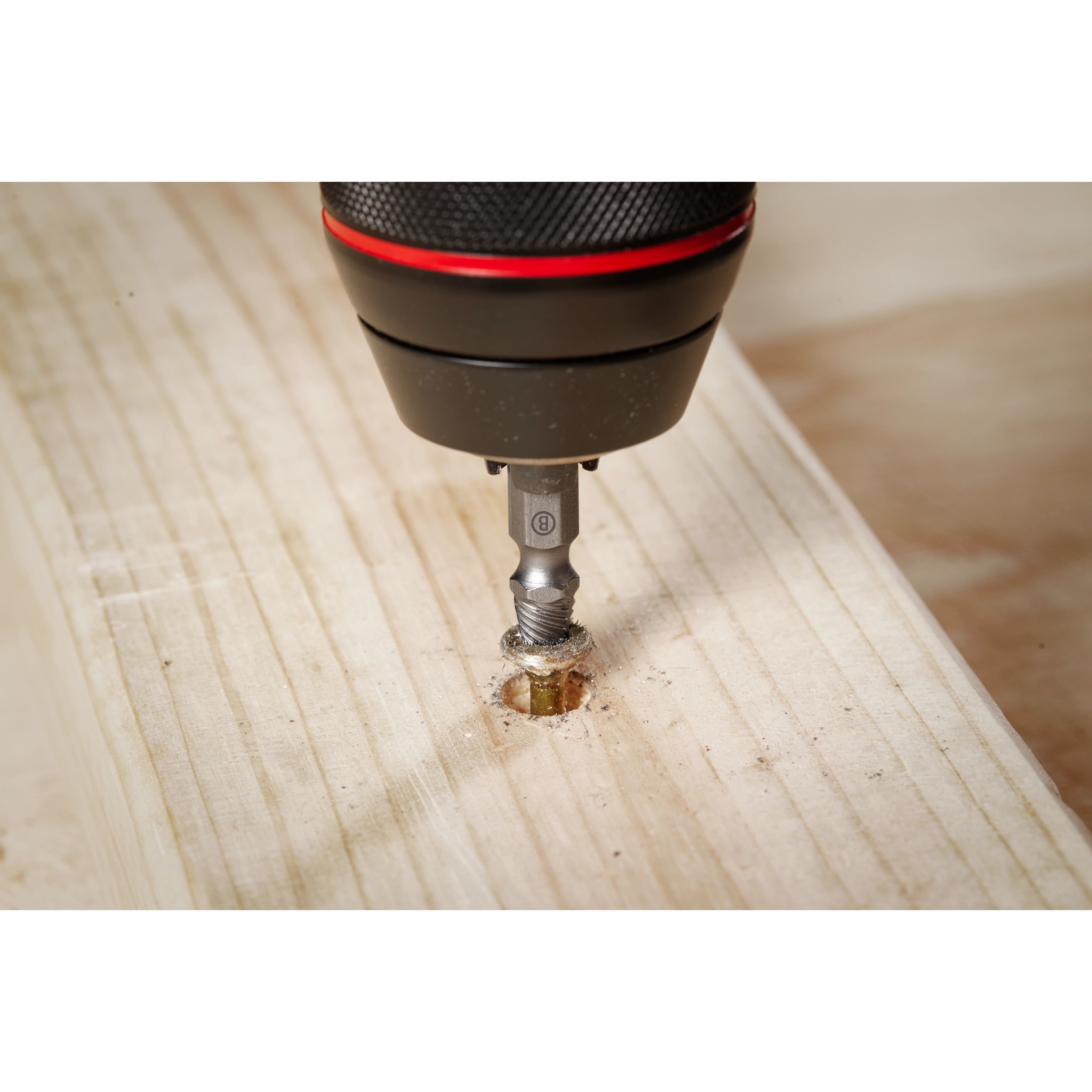 The M2 Steel Screw Extractor Set 4PC is shown in use, with an extractor bit attached to a power drill, removing a damaged screw from a piece of wood. The focus is on the drilling process and the effectiveness of the extractor bit.