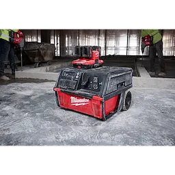 Milwaukee ROLL-ON 7200W/3600W 6.0kWh Power Supply unit on wheels, placed at a construction site with workers in the background.