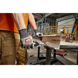 Worker wearing the Cut 4 High-Dexterity Gloves while using a hand tool