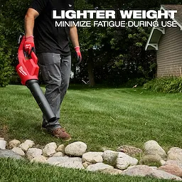 A person uses the Milwaukee M18 Brushless Blower to clear debris from a grassy area bordered by rocks. The text above the person reads, "Lighter weight, minimize fatigue during use."
