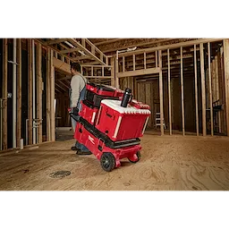 Construction worker transporting red tool storage system on a dolly, featuring a PACKOUT 18oz Insulated Mug with Sip Lid on top.